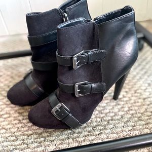Black heeled boots. Faux leather, suede and buckle details.